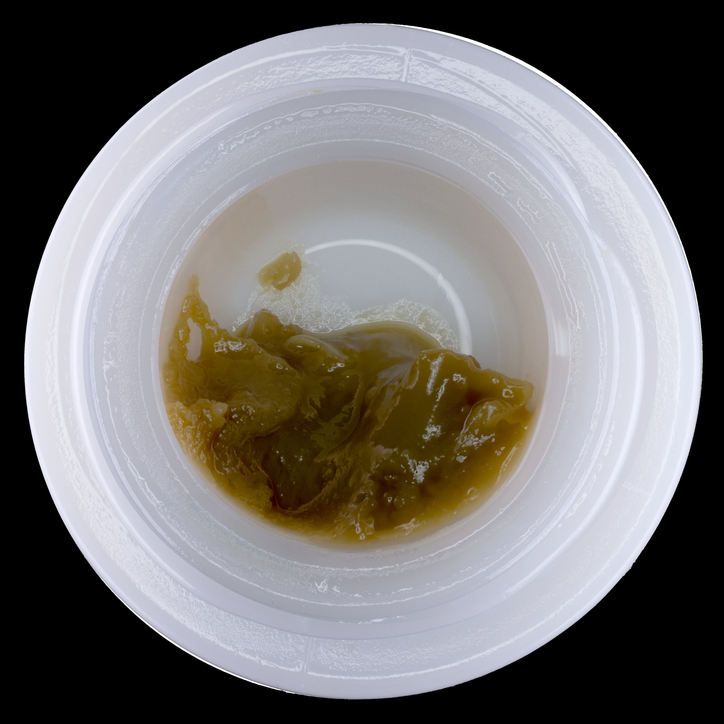 Small container with brownish substance on a white background