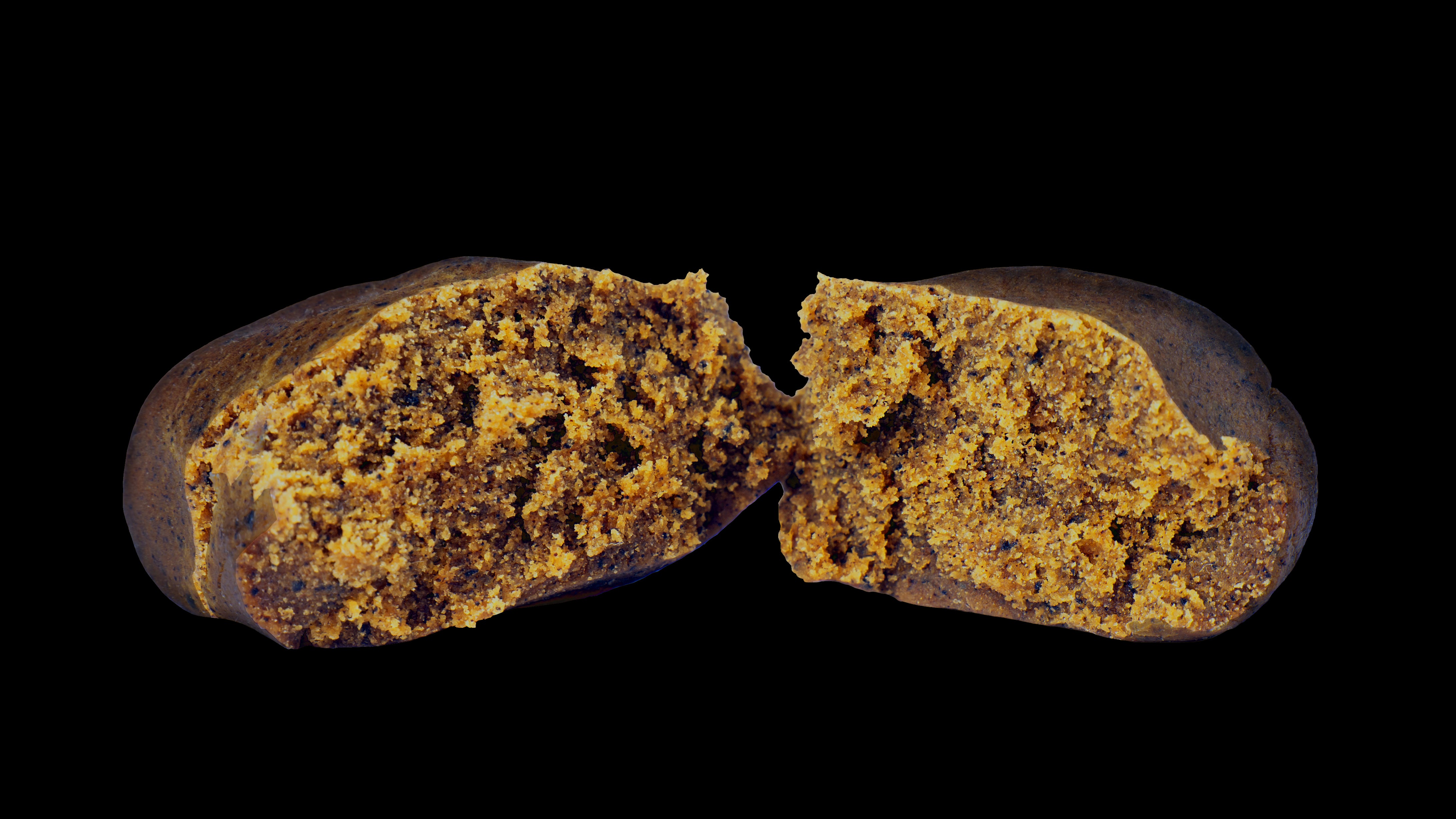 A close-up image of a piece of concentrated hash, showing a dark, dense substance with a crumbly texture, likely to be used for smoking or vaping.
