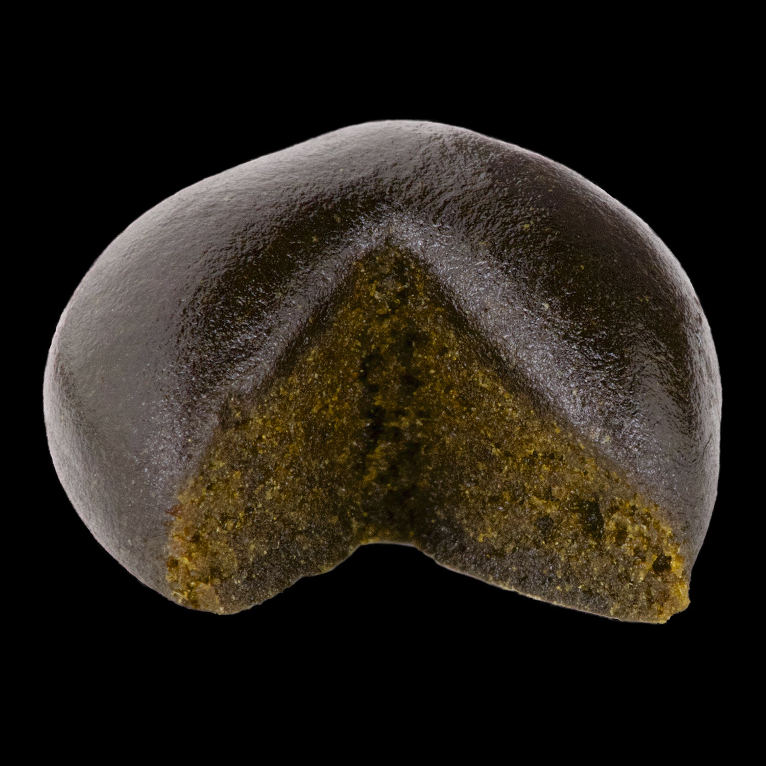 This image features the Exka XK Haschtag CBD Concentrate, presented in a compact and visually appealing form. The concentrate is shown with a dark, glossy exterior and a visible greenish interior, suggesting a dense and potent mixture.