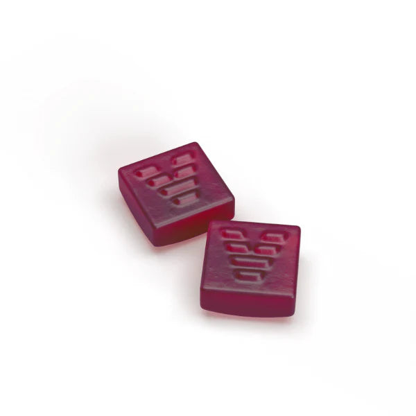 Two red, square-shaped gummies with the Ace Valley logo (a stylized 'V' with a heart shape) embossed on the top surface of each