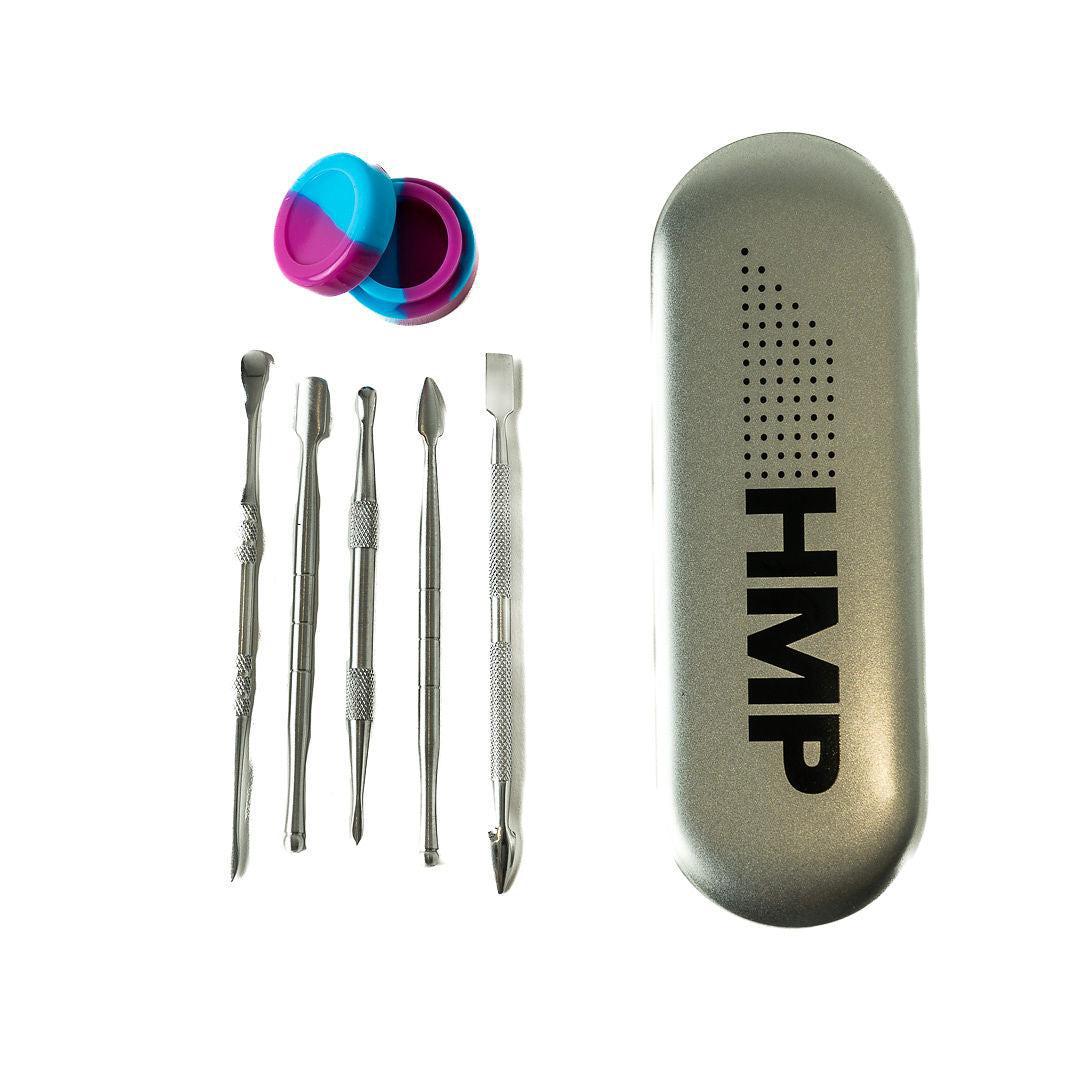A set of metal dab tools with various tips, including scoop and needle-like ends, alongside a silicone concentrate case and a metal case with 'HMP' branding.