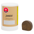 Jubilee cannabis product with a white container and brown hash on a white background