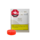 A package of RHO PHOTOSYNTHETIC QUIX THC Rapid Act Gummies, shown with a single round, textured orange-red gummy candy in front of the white and yellow packaging on a solid white background.