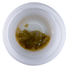 Small container with brownish substance on a white background