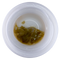 Small container with brownish substance on a white background