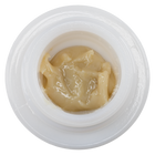 A close-up top-down view of a white circular container filled with a thick, glossy live hash rosin
