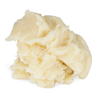 A scoop of creamy, pale yellow solid cosmetic balm or wax with a whipped, textured surface, isolated on a white background.