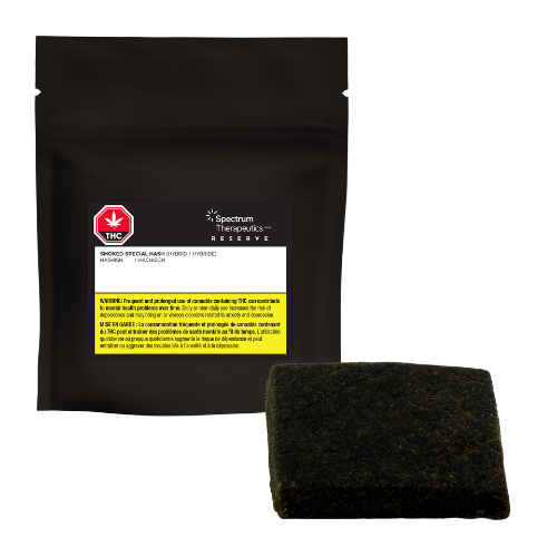 A dark, solid-colored rectangular hashish with black packaging in the background