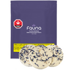 A package of Fauna brand bath bombs, with the product visible in a round shape beside the package. The package is labeled with a THC content warning and has branding elements such as a pine cone illustration.
