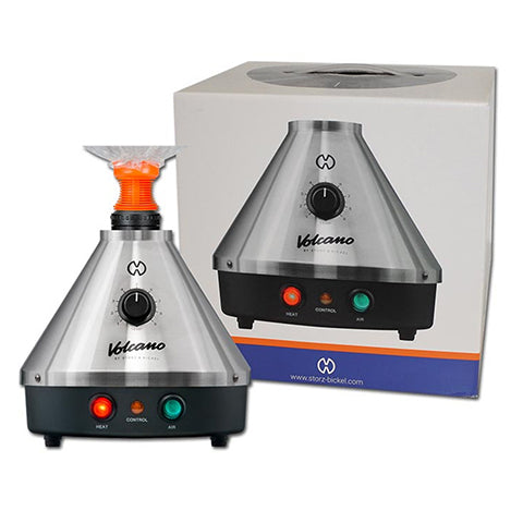 The image shows a Volcano Classic Vaporizer, which is a table-top vaporizing device with a metallic silver finish and a conical shape. It features a control knob on the front and three indicator lights in red, green, and yellow.