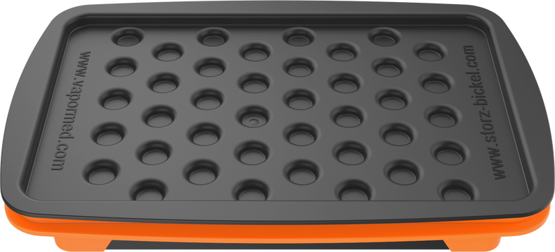 A set of accessories for filling dosing capsules, including a filling device, spatula, plunger, grinder, magazine with sealed capsules, and a scale. The grinder and magazine have orange accents.