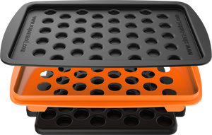 A set of accessories for filling dosing capsules, including a filling device, spatula, plunger, grinder, magazine with sealed capsules, and a scale. The grinder and magazine have orange accents.