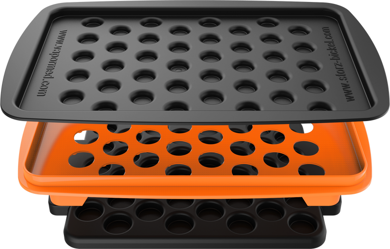 A set of accessories for filling dosing capsules, including a filling device, spatula, plunger, grinder, magazine with sealed capsules, and a scale. The grinder and magazine have orange accents.