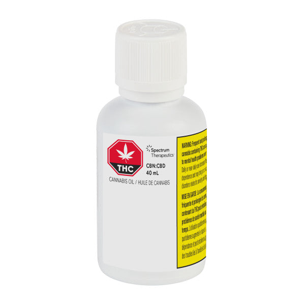 A bottle of Spectrum Therapeutics CBD and CBN oil with a white label and a yellow warning label, containing 40 mL of cannabis oil.