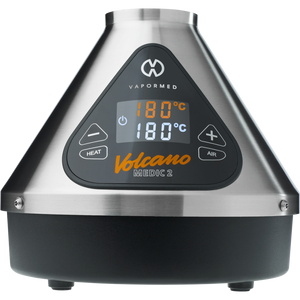 The image shows the Volcano Medic 2 hot air generator, which is a triangular-shaped device with a digital display, touch buttons, and ports for connecting accessories such as balloons and tubes.