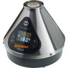 The image shows the Volcano Medic 2 hot air generator, which is a triangular-shaped device with a digital display, touch buttons, and ports for connecting accessories such as balloons and tubes.